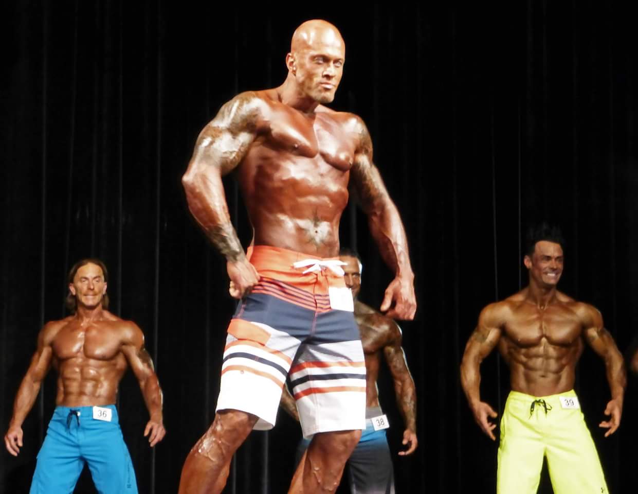 2015-NPC-Powerhouse-Classic-Mens-Physique-Model-John-Quinlan-on-Stage.jpg